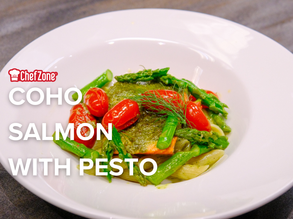 a white bowl with salmon filet and pesto pasta