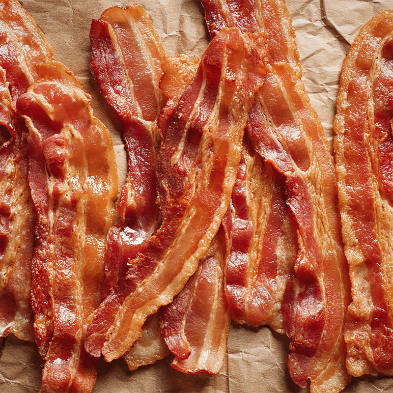 spread of cooked bacon on parchment or kraft paper Pancetta Cubes